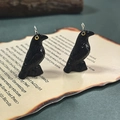 Detail of gothic black resin raven pendant with yellow eyes on vintage paper background - Crow Stepping On Stone