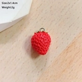 Detaillierte Nahaufnahme eines roten Erdbeer-Anhängers mit Maßen 2x1,4 cm und Metallöse - Rote Erdbeere
