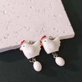 Nahaufnahme von handgefertigten Henne-Ei-Anhängern für kreativen DIY-Schmuck - Weiß