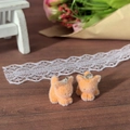 Detail of miniature flocked orange cat charms with metal rings on a wooden desk - Cat
