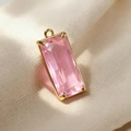Macro detail of rectangle pink crystal pendant with gold metal frame for DIY jewelry - Pink