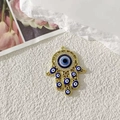 Ciondolo Mano di Fatima dorata con perle Occhio del Diavolo blu e strass lucenti - Traforato Oro Occhio Blu