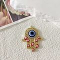 Ciondolo Mano di Fatima dorata con malocchio blu e cristalli su pizzo bianco - Traforato Oro Occhio Rosso