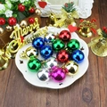 Bunte metallische Weihnachtskugeln auf einem weißen Teller für festliche Dekoration - Kleinster Stil