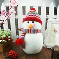 Dettaglio di un pupazzo di neve in peluche con cappello e sciarpa lavorati a maglia - Pupazzo di Neve Cappello Paraorecchie Rosso Grande