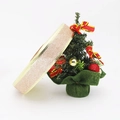 Close-up of champagne gold glitter ribbon roll with gold stitching next to Christmas tree - Champagne Color 2.5cm Wide