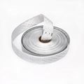 Dettaglio di un rotolo di nastro argento metallizzato con trama a rombi per pacchi regalo - Argento