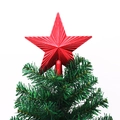 Detailansicht der roten 3D-Stern-Christbaumspitze auf einem grünen Weihnachtsbaumzweig - Rot