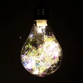 Dettaglio lampadina LED trasparente con fili di rame e frammenti di tinsel colorato - Stile Lampadina