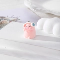 Cute pink flocked pig pendant with white headphones on a white decorative display stand - Headphone Pig