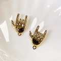 Detailed view of two gold rock-on gesture alloy charms in a white ceramic dish - Smooth Rock Gesture