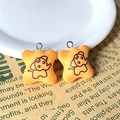 Macro detail of yellow resin biscuit elephant charms with silver metal rings - Elephant Biscuit