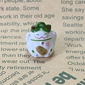 Close-up of alloy Lucky Cat pendant with pink cherry blossom and golden coin detail - Green