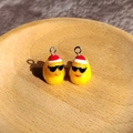 Detailansicht von zwei niedlichen Enten-Anhängern aus Harz mit Sonnenbrille und Mütze - Sonnenbrille Ente Mit Roter Weihnachtsmütze