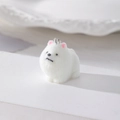 Dettaglio del ciondolo cane Pomerania bianco floccato con orecchie rosa e gancio - Stile Pom