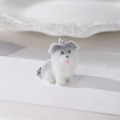 Dettaglio di un ciondolo cucciolo floccato grigio e bianco con trama in pelliccia e anello - Stile Border Collie