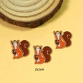 Detailed view of three enamel squirrel pendants with 2x2cm size markers and hanging loops - Squirrel