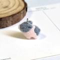 Macro-opname van pluizige roze en grijze varkenshanger met zilveren metalen ringetje - Grijs Roze (Varkensvorm)