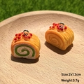 Miniature resin cake roll charms with realistic details and silver metal loops on wood tray - Swiss Bread