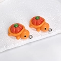 Makroansicht der orangefarbenen Harzschildkröten-Anhänger mit rotem Kakipflaumen-Panzer - Kürbis Schildkröte