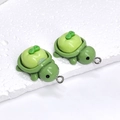 Close-up of green resin apple turtle pendants with silver metal loops for DIY jewelry - Green Apple Turtle