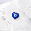 Ciondolo a cuore malocchio blu in lega dorata su una superficie di pietra bianca - Cuore Blu Scuro (N)