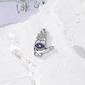 Dettaglio macro della mano di Fatima in argento con occhio blu e cristallo centrale - Stile Mano di Fatima (A) / Argento