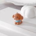Close-up of a brown flocked puppy pendant with blue scarf and silver metal ring - Teddy with Blue Bib