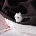 Macro shot of a fuzzy panda charm with soft flocking texture and silver metal ring - Panda