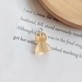 Pendentif poupée en résine jaune translucide avec visage souriant et anneau argenté - Orange clair