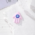 Dettaglio del ciondolo rosa Mano di Fatima con malocchio su superficie in pietra - Rosa Lucido Gocciolamento d'Olio (V)
