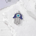 Dettaglio della mano di Fatima con occhio malvagio blu e cristalli su pietra bianca - Argento Smalto Design Radiale (D)