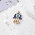 Vista ravvicinata del ciondolo Mano di Fatima in oro con occhio blu e cristalli - Oro Smalto Strass Dita (J)