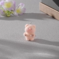Détail d'un pendentif cochon rose floqué avec anneau métallique sur fond texturé - Cochon avec haltère (MR88)