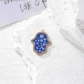 Dettaglio del ciondolo Mano di Fatima dorata con Evil Eye blu e cristalli lucidi - Oro Occhi Multipli Strass (H)