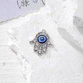 Dettaglio del ciondolo Mano di Fatima con occhio blu e intarsi in cristallo chiaro - Argento Cavo Strass (N)