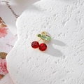 Macro shot of sparkling cherry pendant with red and green rhinestones for DIY jewelry - Red Rhinestone Cherry