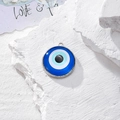 Ciondolo tondo Malocchio con base in metallo argento su sfondo di pietra bianca - Resina Blu Bianco Nero (O)