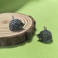 Macro detail of cute resin hedgehog pendant with textured spikes and metal ring for DIY jewelry - Grey Hedgehog