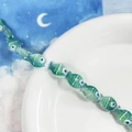 Dettaglio di perline in vetro verde a forma di pesce con motivi malocchio per gioielli fai da te - Stile pesce verde smeraldo (H)