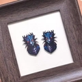 Detailed close-up of blue and purple acrylic dragon charms on a white textured background - Faucet Shape