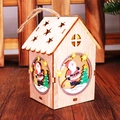 Detailansicht eines beleuchteten Weihnachtshauses aus Holz mit warmem LED-Licht - Weihnachtsmann
