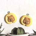 Detailed view of resin capybara charms in yellow cake rolls for DIY jewelry making - Yellow Neck Pillow Style
