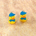 Detailed view of yellow duck charms wearing blue caps and scarves for DIY jewelry - Duck with Hat