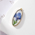 Oval gold pendant with blue dried flower and glitter for DIY jewelry making - Green Leaf Blue Flower