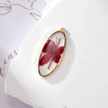 Macro detail of oval resin pendant with red dried flower and gold metal frame for DIY jewelry - Red Flower