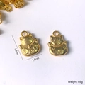 Macro shot of matte gold Maneki-Neko pendant showing lucky charm details and ring hook - Fortune Cat