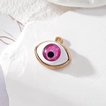 Μακροσκοπική λήψη ροζ μενταγιόν Evil Eye από ρητίνη με χρυσό πλαίσιο σε λευκή πέτρα - Τριανταφυλλί