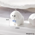 Macro view of white flocked puppy charm with blue bow showing 3cm height measurements - Standing Dog Style