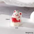 Close-up of a 2.6cm flocked 3D Maneki Neko lucky cat charm holding a red fish - Red Fish